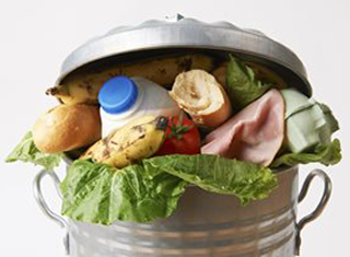 Household garbage bin overflowing with produce and other food 